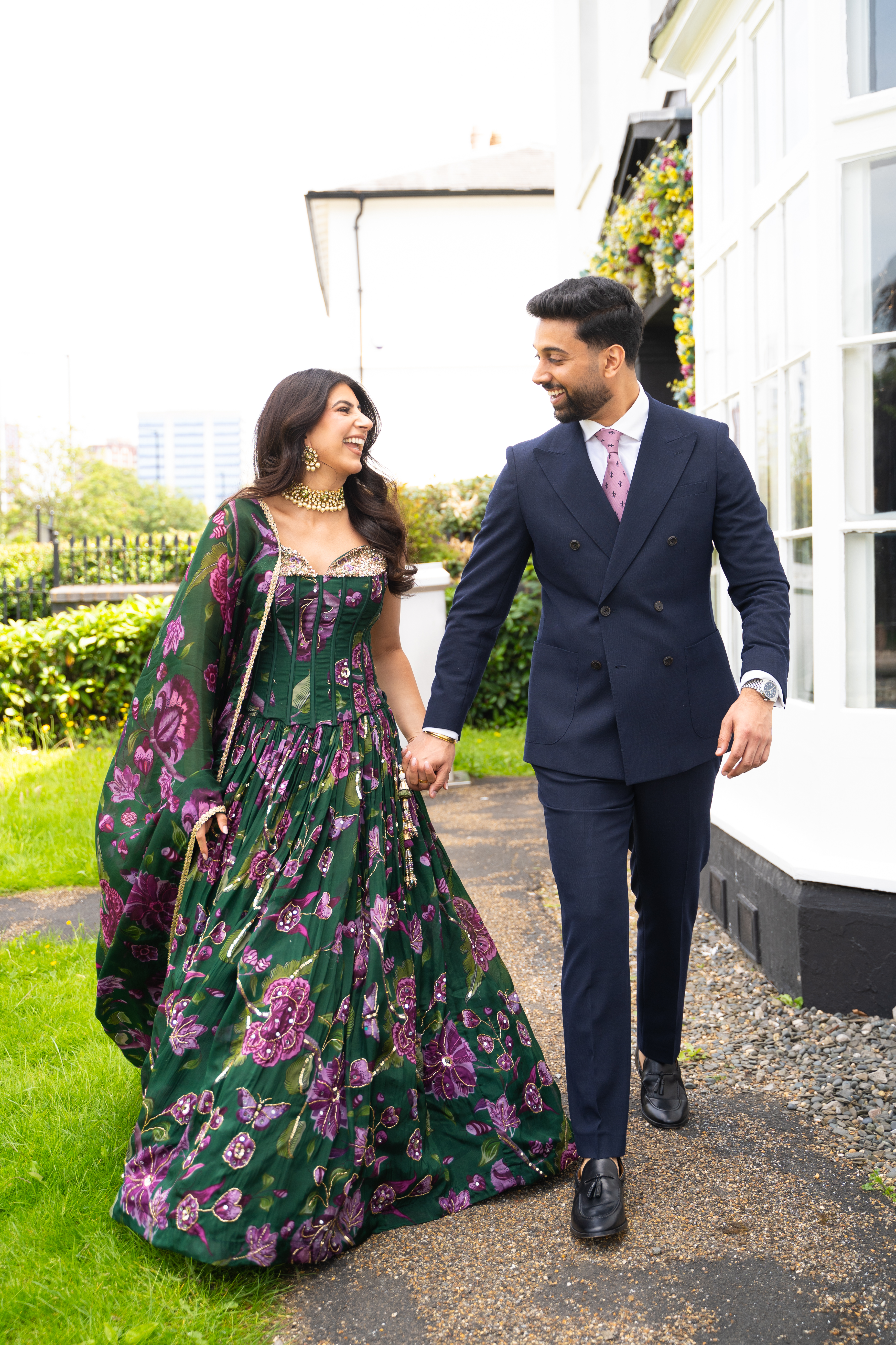 Bride and groom walking through a sunlit English country garden
